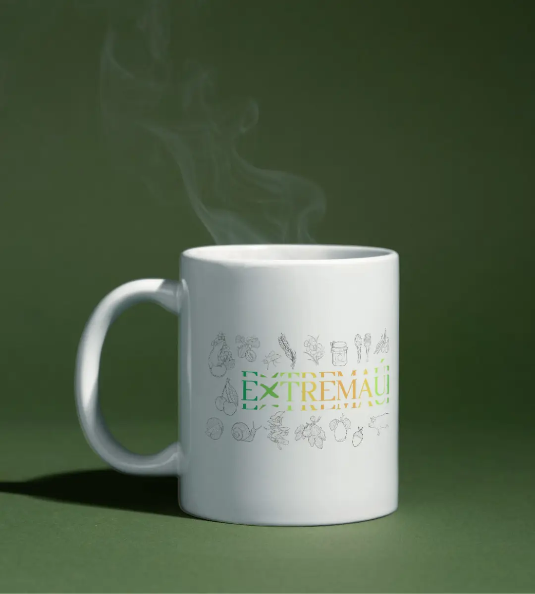 Imagen de la taza Extremaúra de Mijina de Extremadura en perspectiva sobre una mesa de trabajo, mostrando el dibujo a lo largo de la pieza.